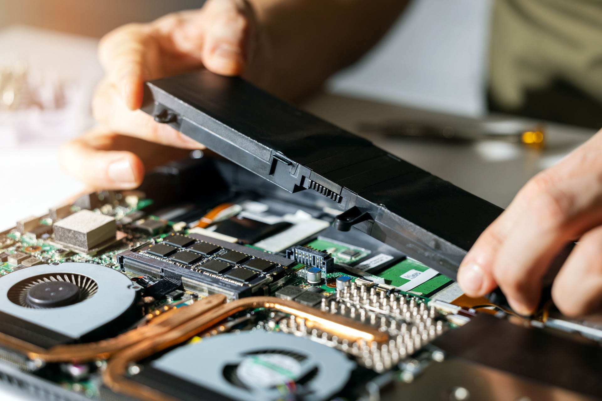 technician change and insert new laptop battery. computer repair service