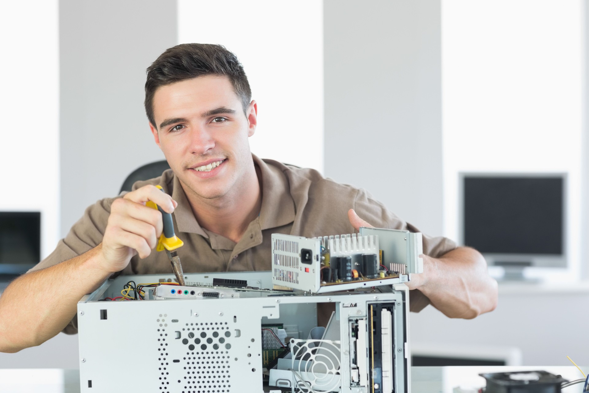 Handsome cheerful computer engineer repairing open Pc